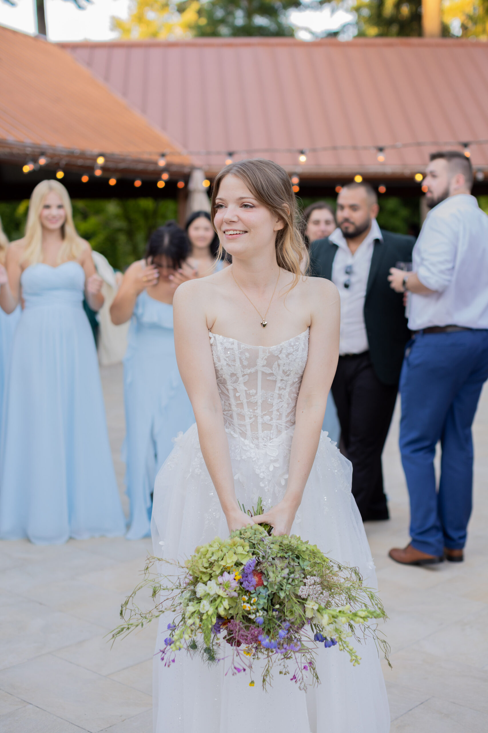 bride-throwing-wildflower-bridal-bouquet-at-wedding-reception