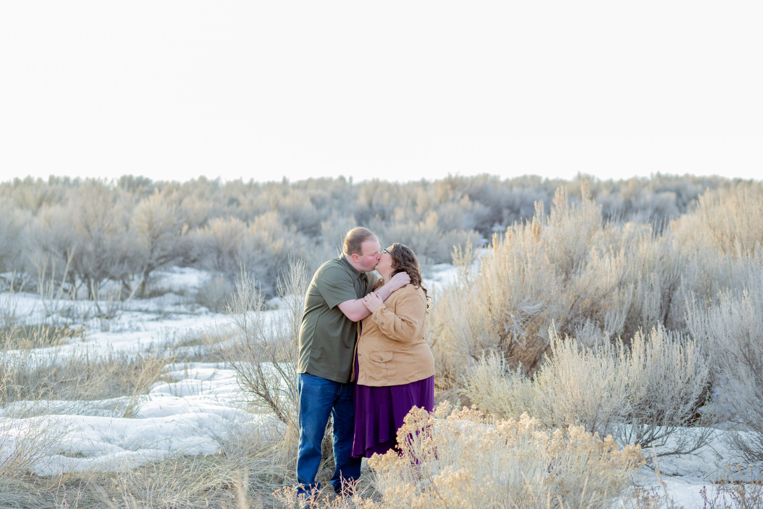couple-standing-kissing-in-sagebrush-field