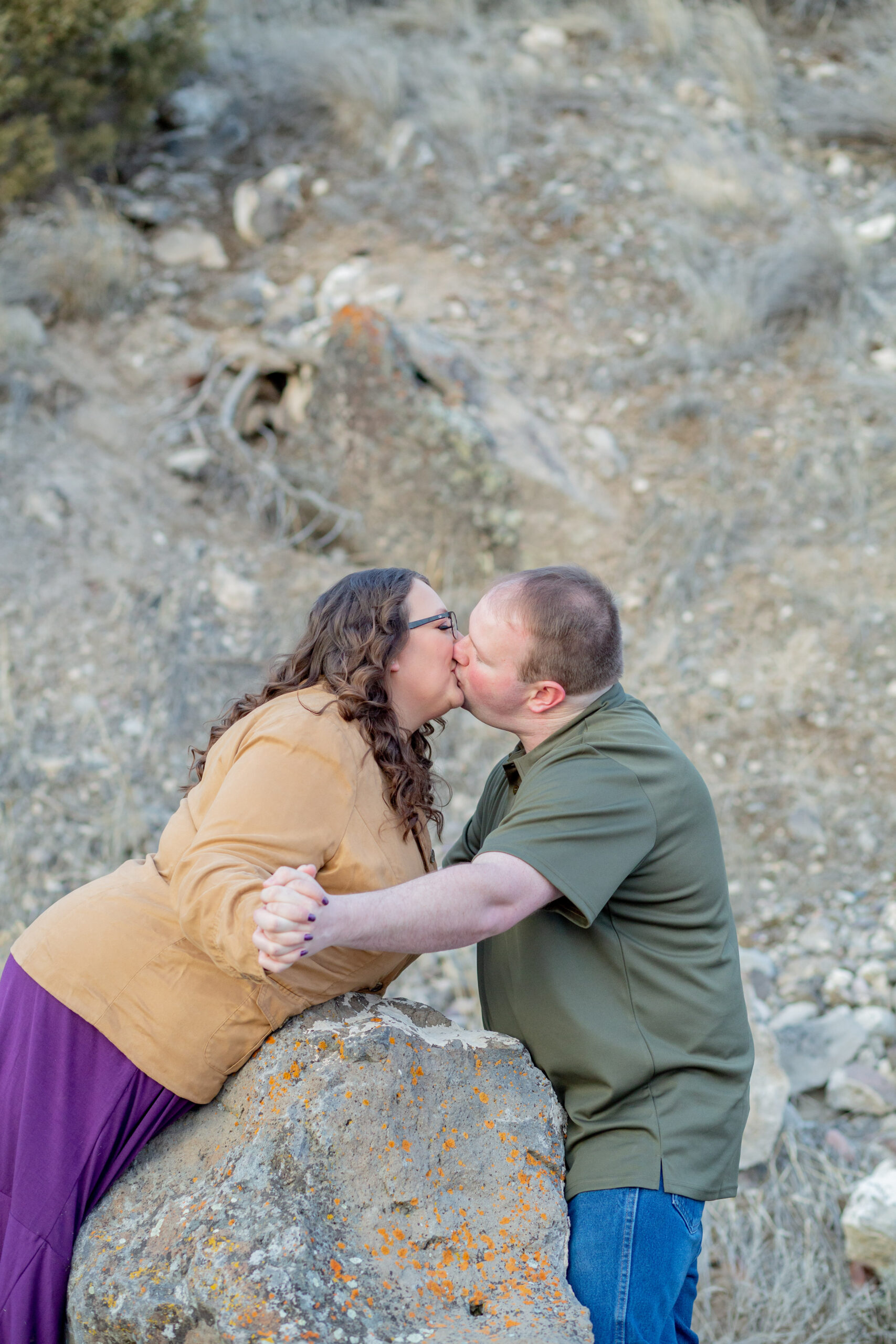 engaged-couple-kissing-over-a-rock