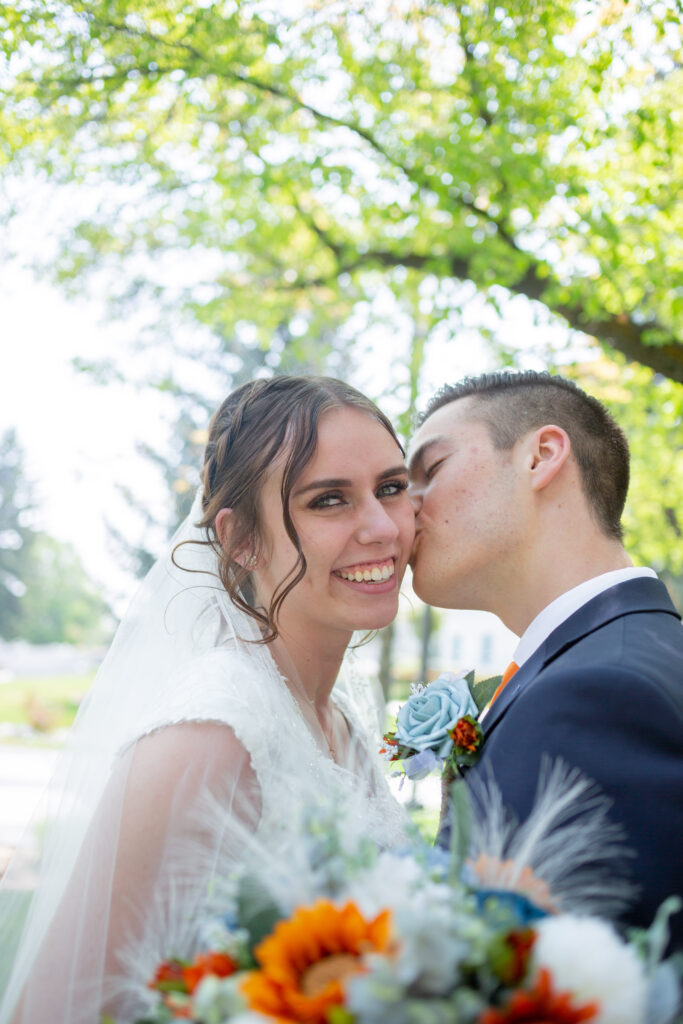 groom-kissing-bride-on-cheek