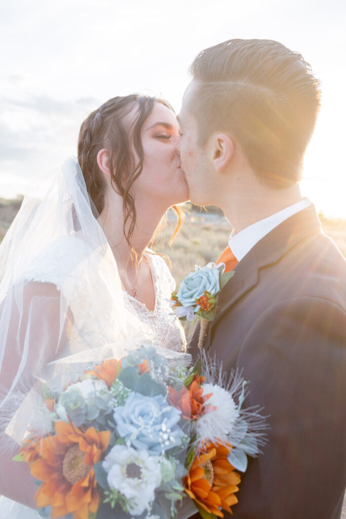 bride-and-groom-kissing-with-sun-behind-them