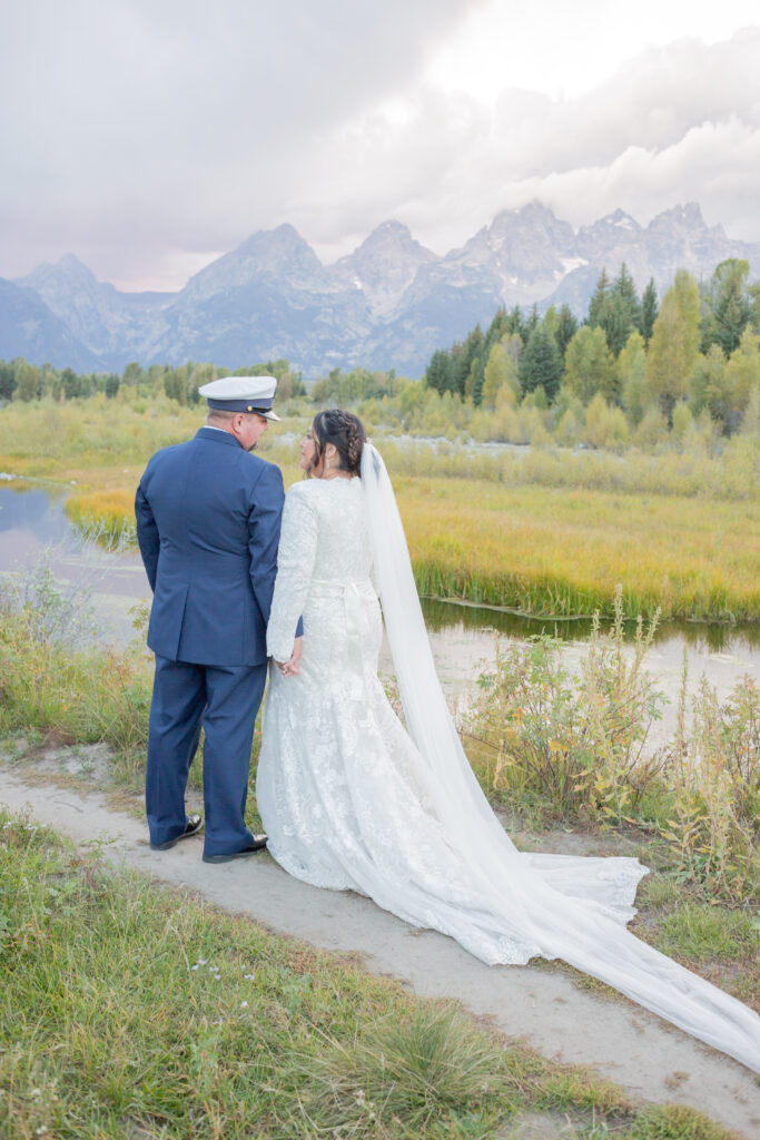 bride-and-groom-holding-hands-with-tetons-in-the-background